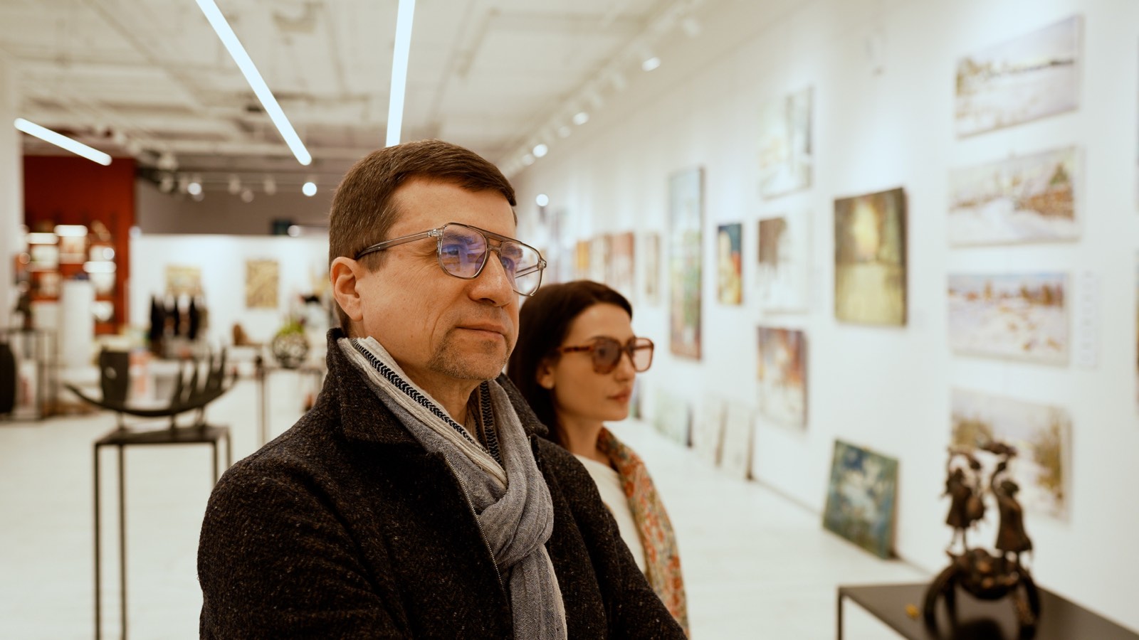 Frammento di uno spazio espositivo con dipinti alle pareti.